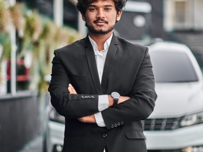 Indian businessman in the background of his car.